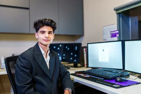 Dr Nikhil Maharaj, founder of Aurelia Private Health, smiling at his desk